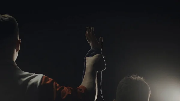 Rear view of the referee who raises the winners hand. The referee raises the hand of the boy winner in the ring