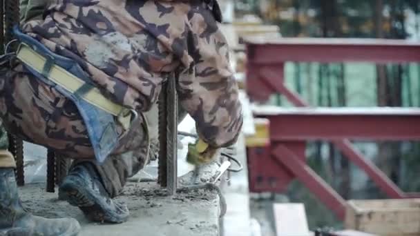 Trabajador de la construcción trabajando en una obra de construcción. Clip. Empleado trabaja en la obra — Vídeo de stock