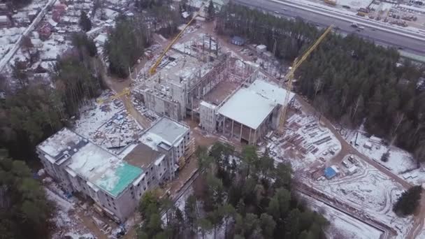 Blick von oben auf die Baustelle eines Stahlbeton-Hochhauses. Clip. Blick von oben auf einen Hochbau mit Turmdrehkranen — Stockvideo