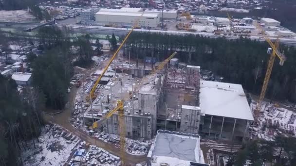 Blick von oben auf die Baustelle eines Stahlbeton-Hochhauses. Clip. Blick von oben auf einen Hochbau mit Turmdrehkranen — Stockvideo