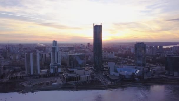 Puesta de sol en Megápolis. Clip. Hermoso paisaje urbano con vista superior en rascacielos. Vista superior de una puesta de sol en el fondo de un rascacielos — Vídeos de Stock