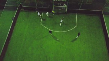 Havadan görünümü futbol sahası amatör futbol oyuncular oyunun şehirde oynanması ile gece. Küçük. Sahada oyuncuların Üstten Görünüm