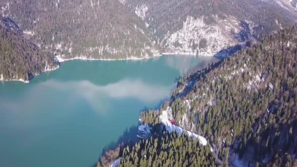 Vista panorámica de hermosos paisajes de maravilla de invierno blanco con cumbres nevadas de montaña. Clip. Lago de montaña cristalino en un día frío y soleado con cielo azul y nubes — Vídeos de Stock