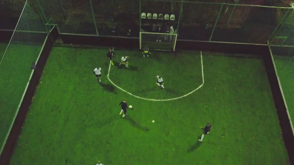 Aerial view of football pitch at night with amateur football players playing the game in the city. Clip. Top view of the players on the court — Stock Photo, Image