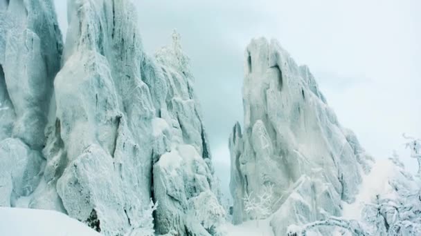 Snowy Rock w lesie. Wideo. ośnieżone skały w górach z czyste niebo. Snowy góry ze składanym warstwy skał — Wideo stockowe