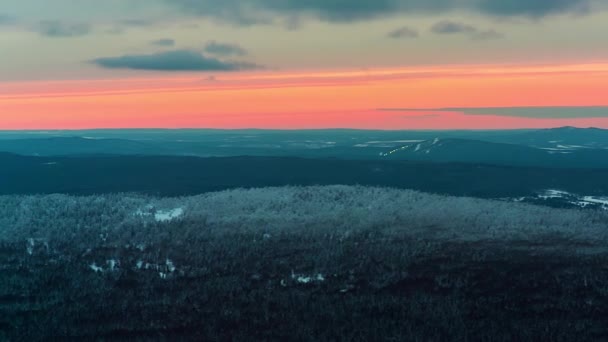 Vista panoramica di tramonto drammatico nelle montagne invernali. Bel tramonto colorato sulla catena montuosa innevata e pineta. Paesaggio naturale. Un video. Nebbia che sorge dalle valli — Video Stock