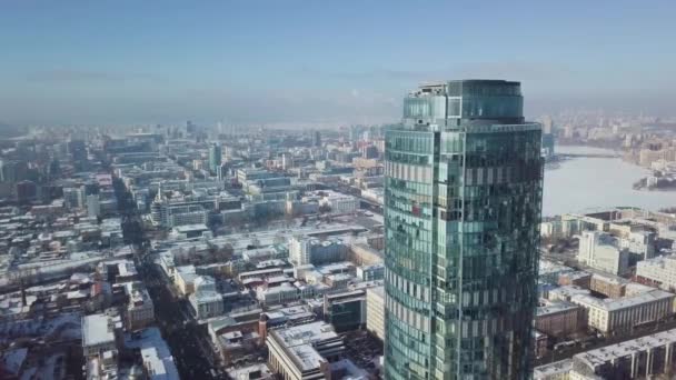 Προβολή επάνω ένα ουρανοξύστη και σύγχρονη πόλη το χειμώνα. Πανέμορφο ουρανοξύστη στον ήλιο — Αρχείο Βίντεο