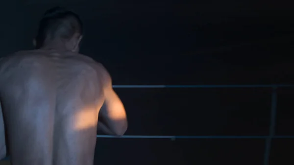 Silhouette adam atlet ayakta ve spor salonunda gölge boks egzersizleri yapıyor. Boxer bir gölge mücadele yapıyor — Stok fotoğraf