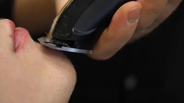 Primer plano de un joven barbudo guapo afeitándose la barba en la peluquería peluquero profesional de su servicio al cliente afeitándose estilo moda masculina —  Fotos de Stock