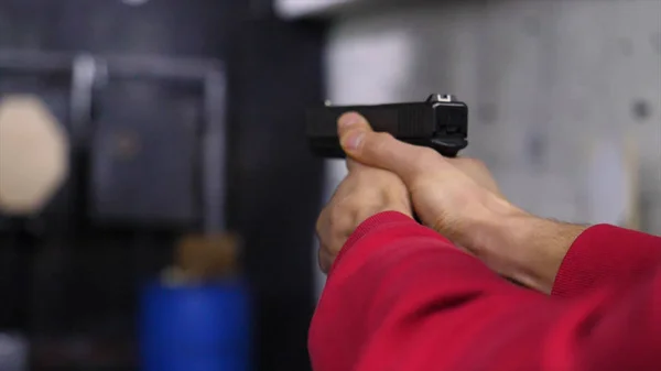 Gun in the mans hand. Man holding a gun close-up. Black handgun in hand of a man