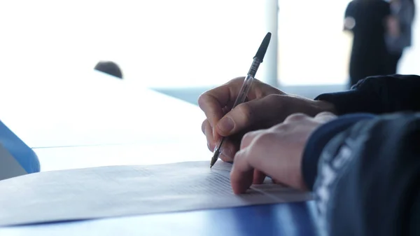 Primer plano de las manos masculinas con pluma sobre documento. El hombre firma el contrato de cerca — Foto de Stock