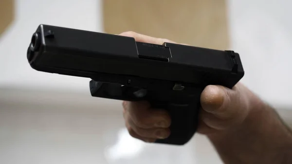 Gun in the mans hand. Man holding a gun close-up. Black handgun in hand of a man — Stock Photo, Image