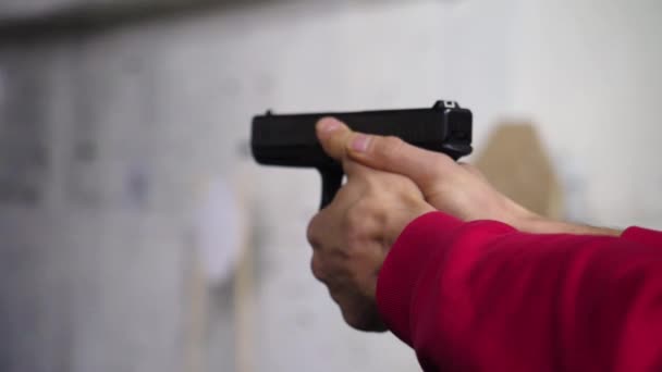 Lag brottsbekämpande syfte pistol för två hand i academy skjutbana i flare. Man skjuter en pistol närbild — Stockvideo