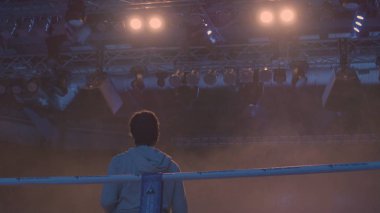 Çalışma Gaffer veya aydınlatma teknisyeni ve Spot arka plan geri görünümü. Aydınlatma teknisyeni, bir film sırasında ışık koyarak. Işık teknisyenleri bir konser sırasında patlayacağı işletim