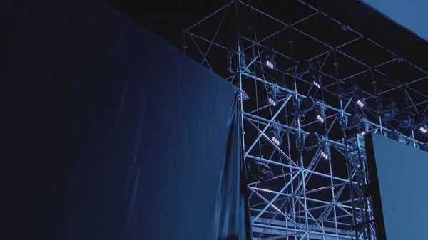 Silueta de un hombre reparando equipo de concierto. El trabajador del escenario instala las luces . —  Fotos de Stock
