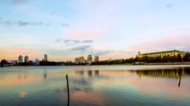 Doğa Manzaralı panorama cityscape, şehir günbatımında gölde yansıyan. Video. Kentsel gece sahne. Bina arka plan ve günbatımı gölün kıyısında Şehir Panoraması