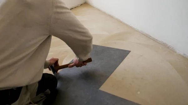 Laying laminate flooring, fitting the next piece - closeup. Man laying laminate flooring. Male Worker laminate flooring