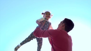 Baba ve kızı gökyüzü karşı. Baba ve alan doğa günbatımı ışığı oynayan çocuk. Baba küçük kızı bir çayırda oynarken. Eğlenceli birlikte, kalite vakit geçiriyor