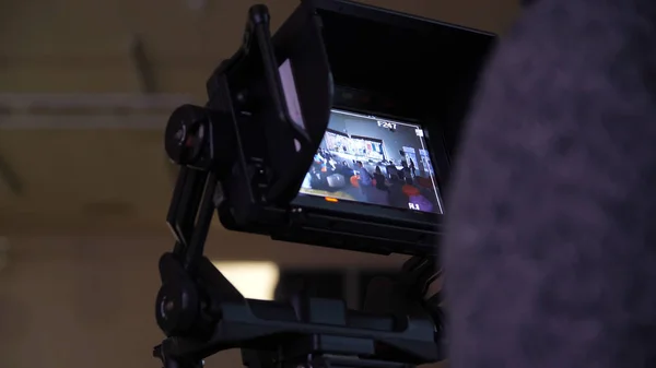 Dans les coulisses de la télévision film vidéo tournage équipe de production et l'éclairage de la caméra se déroule dans le grand studio. Caméra numérique professionnelle en studio. Cameraman travaillant avec l'annonceur dans — Photo