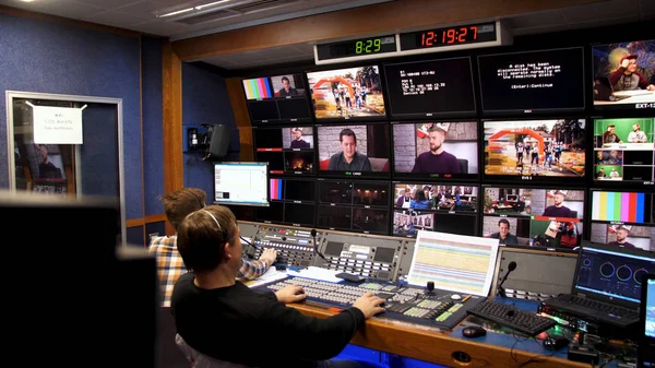 Rusia, Moscú - 12 de enero de 2017: director de televisión en el editor en el estudio. Director de televisión hablando con mezclador de visión en una galería de televisión. El hombre se sentó en un panel de mezcla de visión en un estudio de televisión —  Fotos de Stock