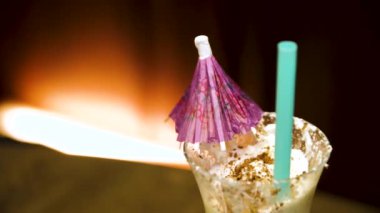 Krem ve içecek saman ile çilekli milkshake. Beyaz sallamak cam şemsiye ile yakın çekim
