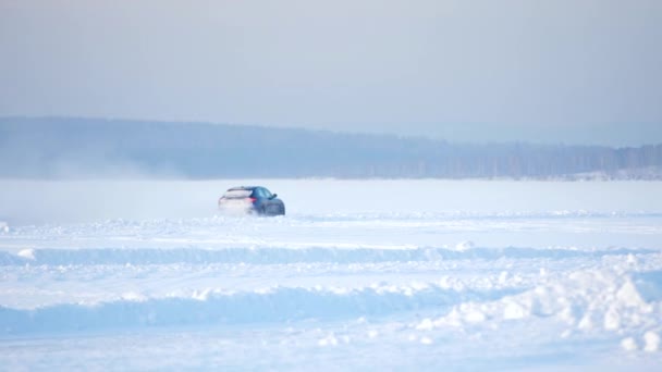 Vezetés a hóban. Téli autó követi nyomon, a havas beach. Vezetői egy versenyautó a havas úton. Nyomon követheti a téli autóverseny nap tükörképe. Versenyezni a pályán, a téli — Stock videók