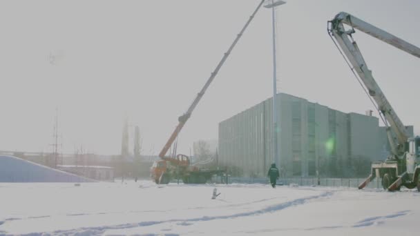 Constructor en una plataforma de elevación en un sitio de construcción. Hombres en el trabajo. trabajador de la construcción montaje de andamios en el sitio de construcción. Los hombres montan Billboard en grifo — Vídeo de stock