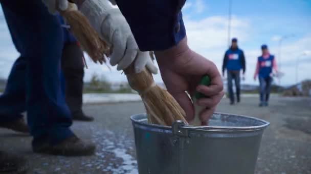 Händer doppa färg i en full färg kopp. Klipp. Närbild av en arbetare hans penseln i färgen. Arbetstagare i blått doppa penseln i färg — Stockvideo