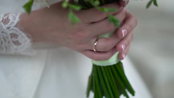 Ωραίο γαμήλιο μπουκέτο σε χέρι νύφες. Κλιπ. Αρραβωνιαστικιά σε ένα όμορφο λευκό φόρεμα που κατέχουν ένα όμορφο μπουκέτο λουλούδια γάμου έκανε προσφορά τριαντάφυλλων στο χέρι — Αρχείο Βίντεο