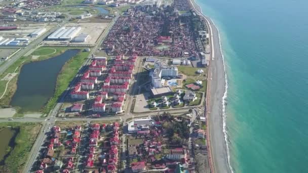 Parte de la moderna ciudad turística cerca del mar en un día soleado. Clip. Vista superior de la ciudad turística cerca del mar — Vídeo de stock