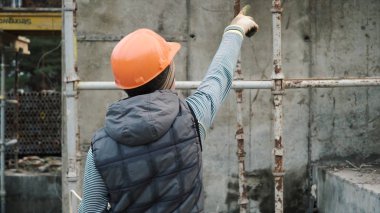 Oluşturucu Geliştirici kavramı planlama inşaat işçisi. Küçük. Parmağını Oluşturucusu kask içinde ortaya