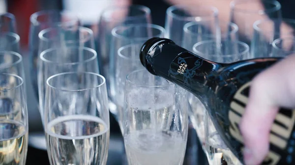 Gieten champagne in een glazen op tafel staan. Clip. Champagne wordt gegoten in glazen — Stockfoto