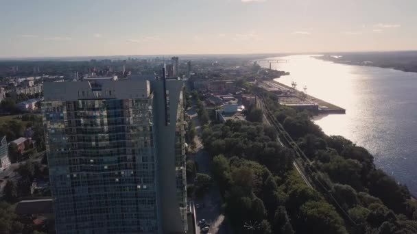 Stadtbild tagsüber fast abends. Clip. Blick von oben auf das hohe Gebäude in Flussnähe an einem sonnigen Tag — Stockvideo