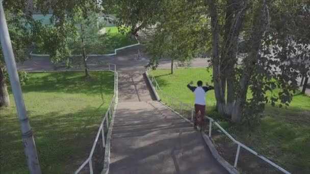 Agresivo rodillo en línea moler en carril en skatepark exterior. Clip. Deportes extremos de verano haciendo ejercicio al aire libre en skate park. Varios trucos — Vídeo de stock