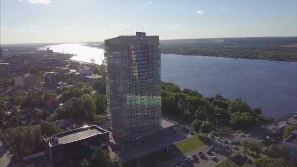 Luftaufnahme von Fluss und modernem Gebäude. Clip. Schönes Stadtbild bei Sonnenuntergang — Stockvideo