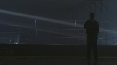 Savaşçı adam siluet karanlık. MMA savaşçı siluet karanlık halkası üzerinde. Boksör mücadele önce sahnede duruyor. Boksör siluet duman karanlık stüdyoda. Arkadan görünüş adam boks halka yakın Tarih