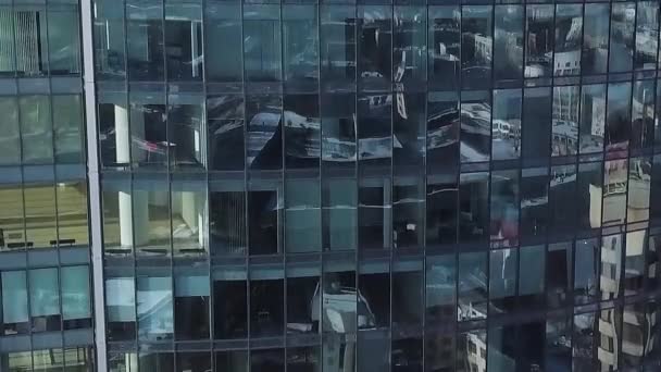 Närbild av fönster i modern skyskrapa. Moln refelected i modern kontorsbyggnad. Zoom och panorering. Antenn. Smidig kamerarörelse framför kontorsbyggnad windows återspeglar solig blå himmel — Stockvideo