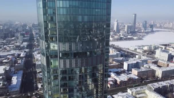 Widok z góry wieży niesamowite szkła lub centrum biznesowego w tle miasta zimowych. Widok na wieżowiec jest w centrum miasta w zimie, niebo błękitne niebo i zaśnieżonych dachów — Wideo stockowe