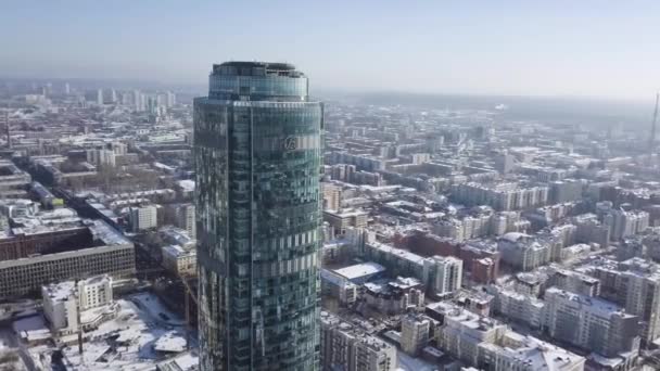 Luchtfoto van wolkenkrabber is midden in de stad in de winter, blauwe hemel hemel en besneeuwde daken van gebouwen achtergrond — Stockvideo