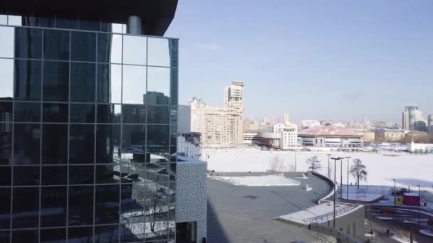 Blaue Glaswand eines Wolkenkratzers mit Sonnenreflexion. Moderne Architektur mit Sonnenstrahl aus der rechten Ecke. Sonnenlichtreflexion auf Glasgebäuden. Querfeldein-Foto über die Autobahn — Stockvideo