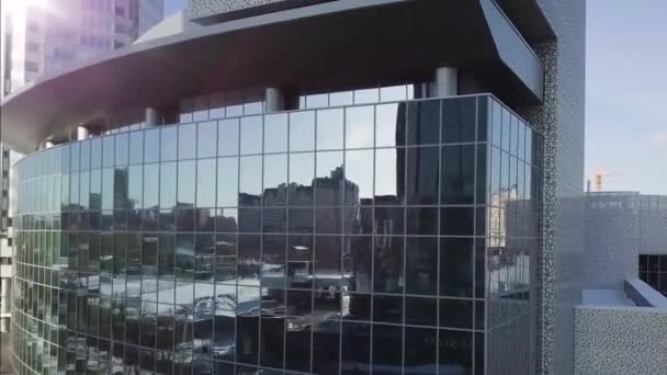 Reflexões abstratas de edifícios altos da fachada de arranha-céus de vidro. Voando em torno da fachada vazia em branco do edifício de escritórios com reflexões, especular — Vídeo de Stock