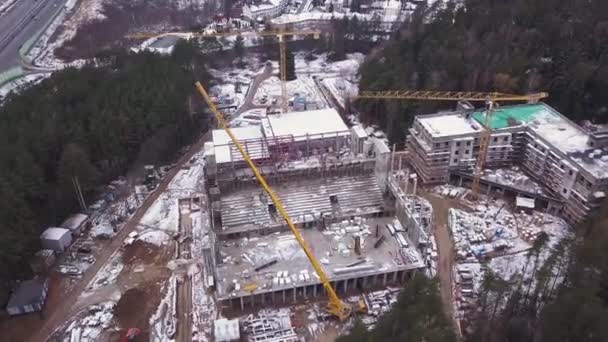 Luchtfoto van een grote bouwplaats. een Residentieel hoogbouw gebouw en een bouw-kraan. Bouw van hoogbouw in de winter. Luchtfoto. — Stockvideo