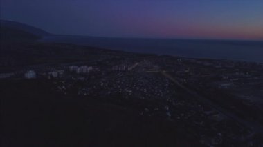Gece gelen bir kuş bakışı görünüme Sochi şehir panoraması. Küçük. Sochi Panoraması havadan. Evler, sokaklar, ağaçlar, gece gökyüzü görünür. Uzaktan deniz görebilirsiniz. Sochi, Rusya Federasyonu