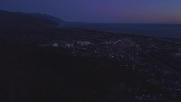 Gece gelen bir kuş bakışı görünüme Sochi şehir panoraması. Küçük. Sochi Panoraması havadan. Evler, sokaklar, ağaçlar, gece gökyüzü görünür. Uzaktan deniz görebilirsiniz. Sochi, Rusya Federasyonu — Stok video