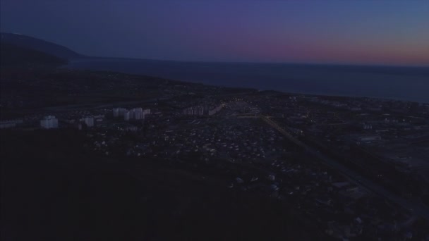 鳥の目のビューからソチ市内の夜景。クリップ。空気からソチのパノラマ。住宅、道路、木、夜の空が表示されます。遠くに海を見ることができます。ソチ、ロシア — ストック動画