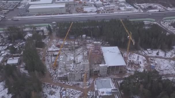 Flying high above big and dusty heavy industry construction site zone, winter. Clip. Constructing and widening stunning wild vast green lush forest — Stock Video