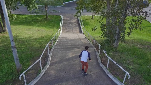 Agressieve inline roller blader grind op rail in skatepark buiten. Clip. Zomer extreme sport uitoefenen buiten in het Skatepark. Diverse trucs — Stockfoto