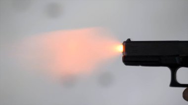 Kapatın profil adam bir 9 mm tabanca tutan bir atış sonra alır. Adam kapalı atış poligonuna el silah patlar. Yakın çekim. 9 mm tabanca ile adam bir ateş etti. Yukarıdan bir açı ile ateş. Holding adam bir