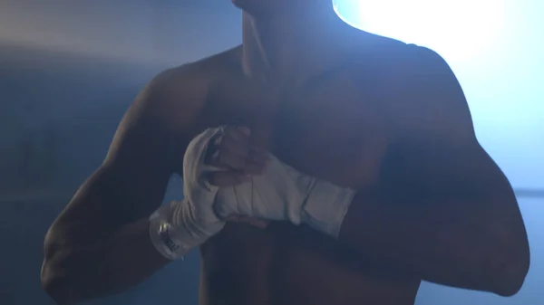 Halve lengte portret van naakt boxer met handen op de heupen, op een donkere achtergrond met licht, close-up. Jonge knappe mannelijke vechter permanent geconcentreerd voor strijd met het samenstellen van palmen — Stockfoto