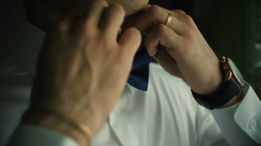 Adam papyon ayarlamakta. Klip. Beyaz gömlek genç adam yakın çekim ayakta iken onun papyon ayarlama